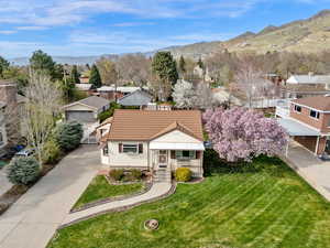 View of front of property featuring a residential view, a front yard, a tile roof, a mountain view, and driveway