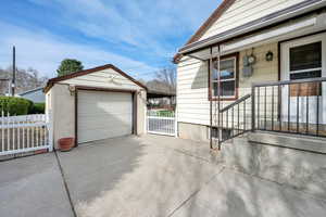 Detached garage featuring fence and concrete driveway