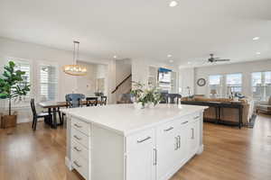 Kitchen with light wood finished floors, plenty of natural light, and ceiling fan with notable chandelier