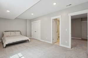 Bedroom with light colored carpet, baseboards, visible vents, and recessed lighting