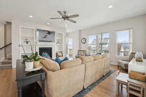 Living area featuring ceiling fan, light wood-type flooring, recessed lighting, and built in shelves