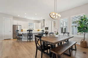 Dining room featuring a notable chandelier, light wood-type flooring, baseboards, recessed lighting, and visible vents