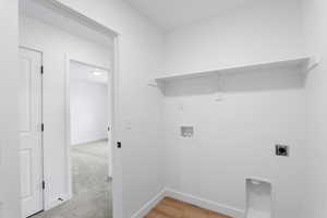 Clothes washing area with baseboards, washer hookup, hookup for an electric dryer, and laundry area