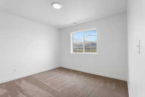 Carpeted spare room featuring visible vents and baseboards