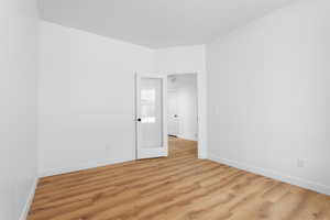 Unfurnished room featuring light wood finished floors, baseboards, and visible vents