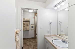 Bathroom with tile patterned floors, heating unit, vanity, and baseboards