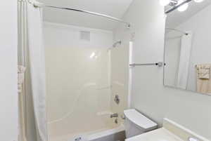 Bathroom with toilet, shower / bathtub combination with curtain, and visible vents