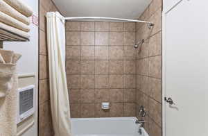 Bathroom with shower / bath combo and a textured ceiling