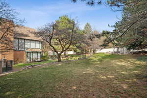 View of yard with a shed, an outdoor structure, and fence