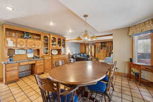 Dining room with built in study area, visible vents, an inviting chandelier, and light tile patterned flooring