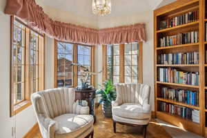 Sitting room featuring baseboards and an inviting chandelier