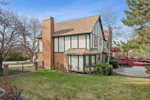Rear view of house with fence, a patio area, a yard, and a chimney