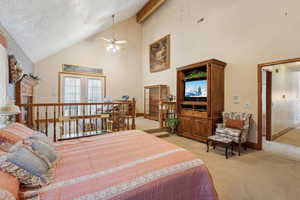 Bedroom featuring high vaulted ceiling, a textured ceiling, visible vents, light carpet, and baseboards