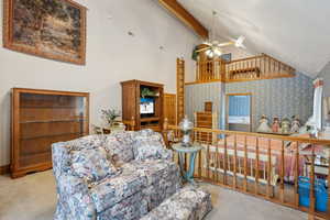 Carpeted bedroom featuring high vaulted ceiling, wallpapered walls, and beam ceiling