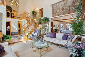 Carpeted living area with a chandelier and stairs