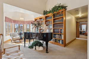 Living area featuring visible vents, baseboards, a chandelier, and carpet floors