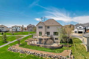 Back of house featuring a patio area, stucco siding, a residential view, and a lawn