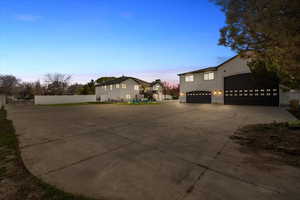View of home's exterior with concrete driveway, stucco siding, and fence