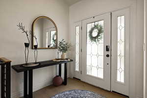 Foyer with wood finished floors and a healthy amount of sunlight