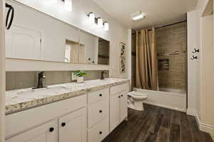 Full bathroom with decorative backsplash, a sink, toilet, and wood tiled floor