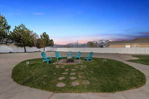 Yard at dusk featuring a fenced backyard and an outdoor fire pit
