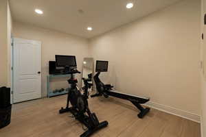 Workout room featuring baseboards, light wood-type flooring, and recessed lighting