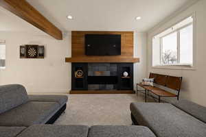 Living area featuring recessed lighting, carpet flooring, baseboards, and beamed ceiling