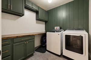 Laundry room featuring independent washer and dryer, tile patterned floors, cabinet space, and a textured ceiling