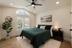 Bedroom featuring visible vents, baseboards, wood finished floors, and lofted ceiling