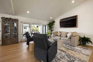 Living area featuring lofted ceiling, recessed lighting, and light wood-style floors