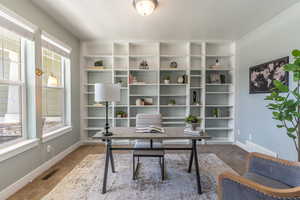 Office/Library with carpet and built-in shelving.