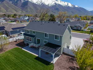 Back of house with a residential view, a fenced backyard, a mountain view, a yard, and stucco siding
