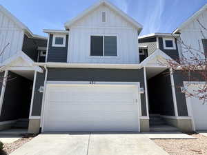 View of front of property featuring board and batten siding, an attached garage, and concrete driveway