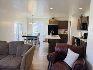Living area featuring a chandelier, a textured ceiling, light wood finished floors, and recessed lighting