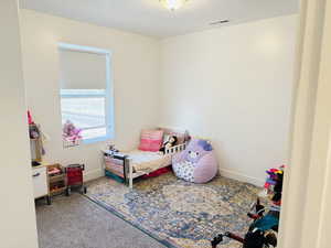 Carpeted bedroom with visible vents and baseboards