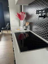 Details with wood finished floors and black electric cooktop