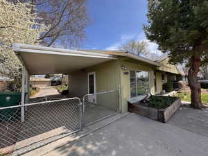 View of side of property featuring a carport, fence, and a gate