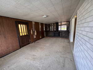 Interior space with a wood stove, wooden walls, and carpet