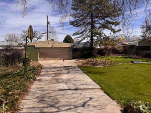 View of yard with driveway to Oversized 2 car garage with workshop