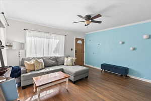 Living area featuring hardwood flooring, crown molding, ceiling fan, and a wealth of natural light
