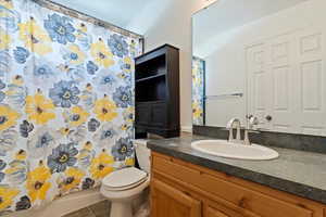 Full bathroom with toilet, tile patterned floors, and vanity