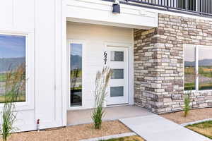 Doorway to property with a mountain view and stone siding