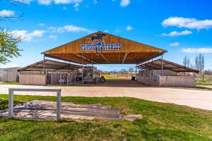 Large stables structure featuring a prominent wood-finish facade and metal roofing