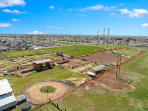 Expansive property featuring multiple fenced enclosures, a round pen, and a large arena area