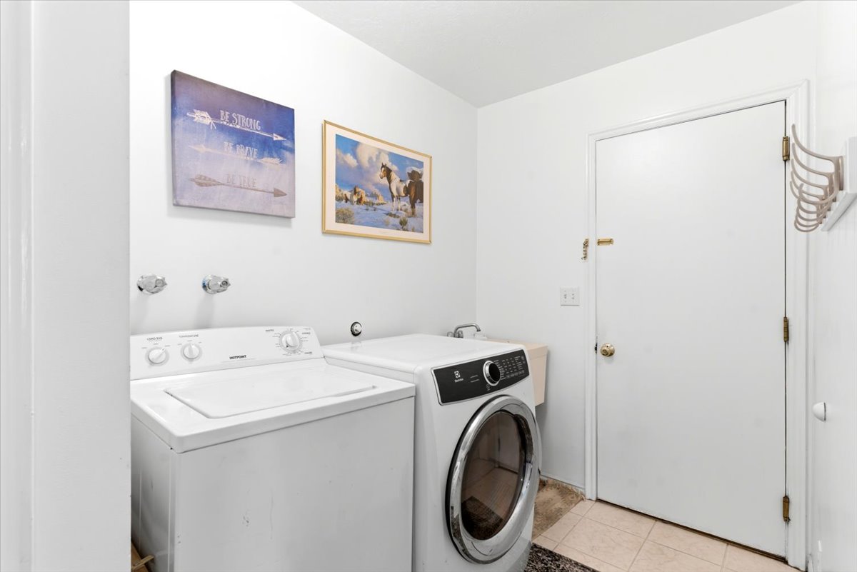 Dedicated laundry area featuring a white top-load washing machine and a front-load dryer