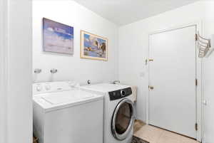 Dedicated laundry area featuring a white top-load washing machine and a front-load dryer