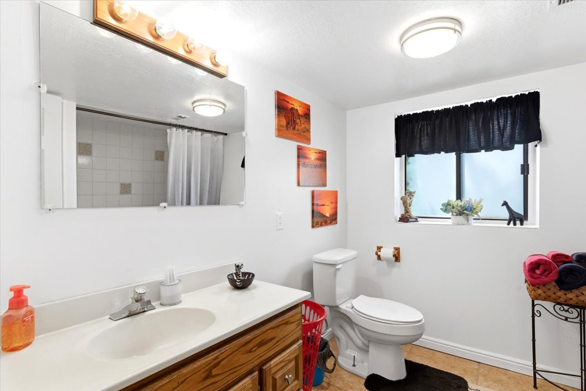 Bathroom with a single vanity featuring a wood-finish cabinet and a white countertop