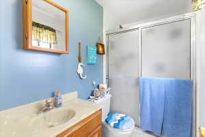 Bathroom featuring a wood-finish vanity with an integrated sink and a cultured marble countertop