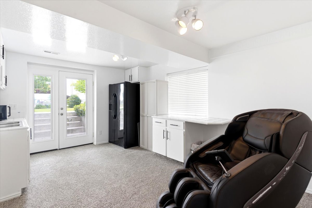 Light-filled space featuring French doors, white cabinetry, a built-in countertop, and track lighting