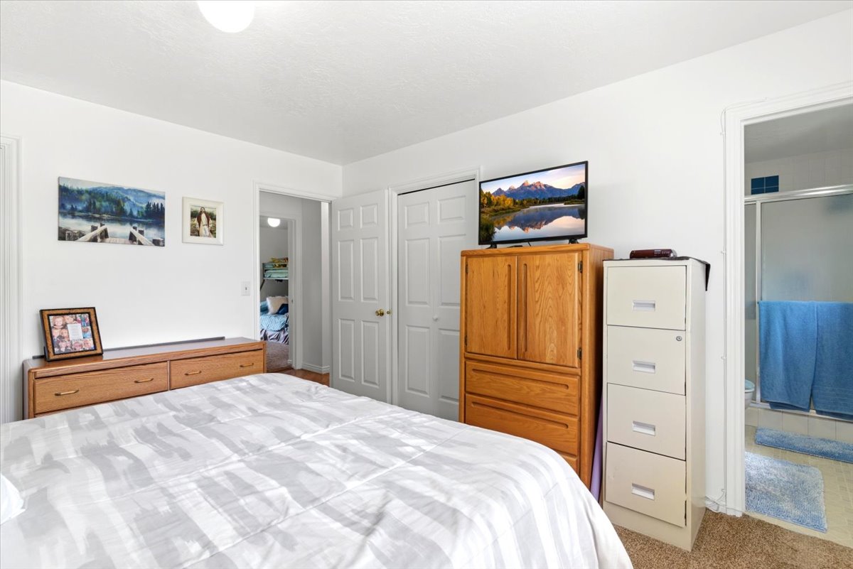 Carpeted bedroom with a built-in closet featuring bi-fold doors